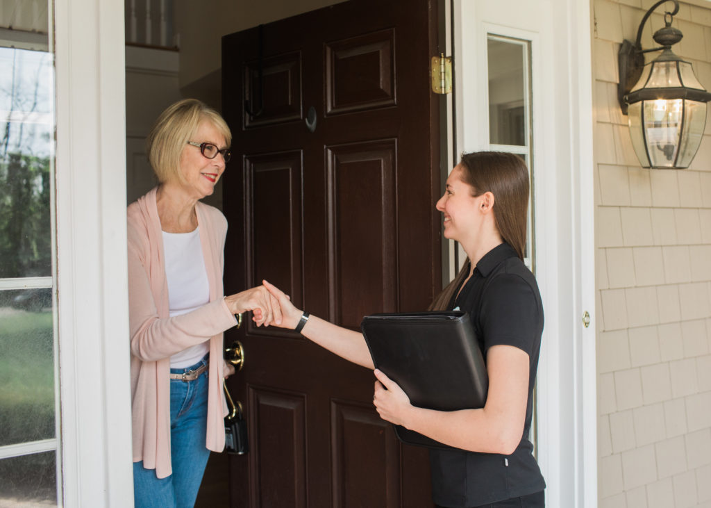 Owner Allison meeting and shaking hands with female client at their front door