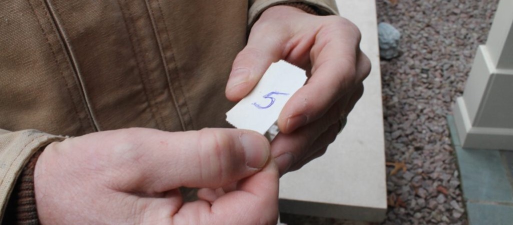 person holding a little tag with the number 5 on it