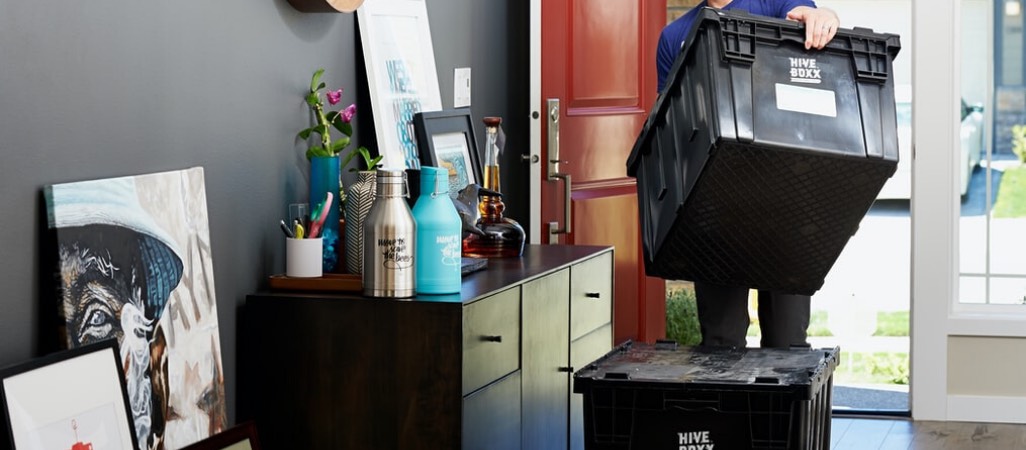 large black totes being stacked in the front door of a home