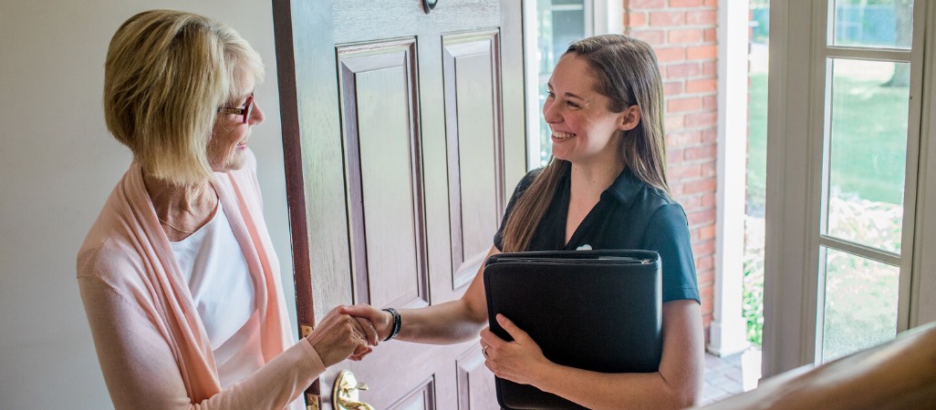 Owner Allison shaking hands with a client while entering her house