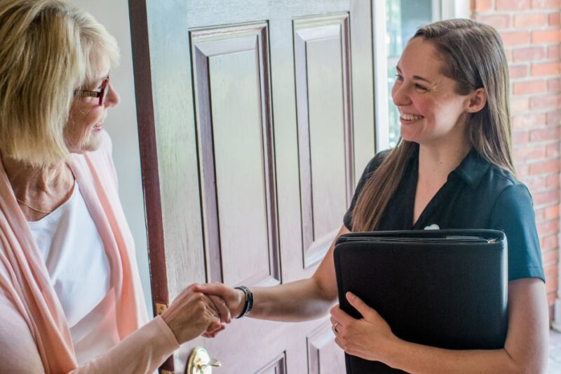 Allison Ruby of Poof Estate Services shaking customers hand in home doorway