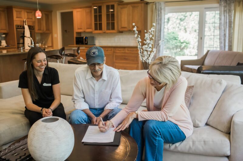 Owner Allison with clients signing a contract in their living room