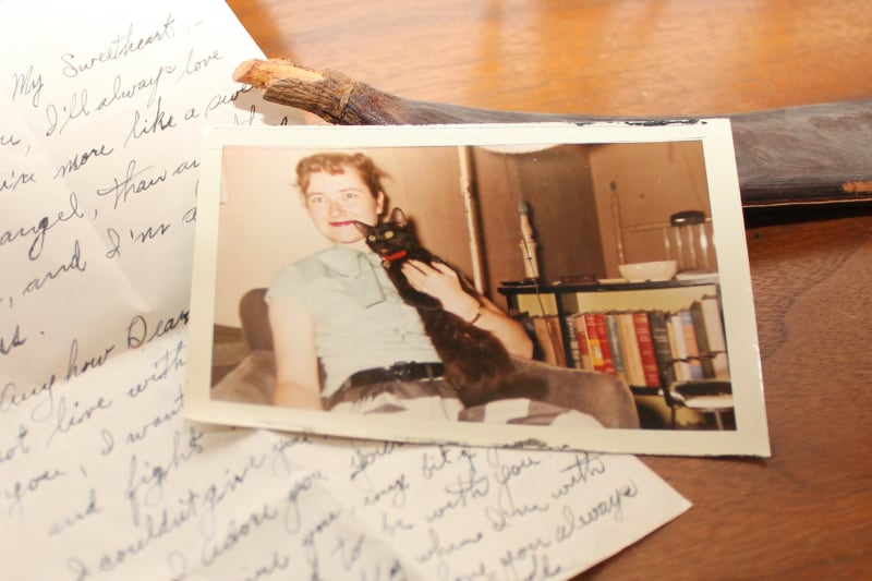 Old picture of woman holding a cat sitting on top of a handwritten letter