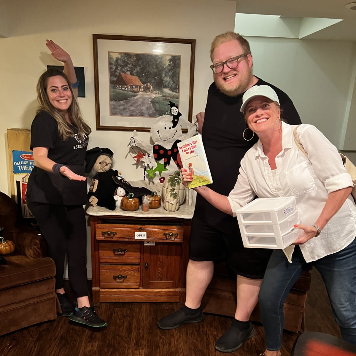 Three Poof employees smiling in front of a display