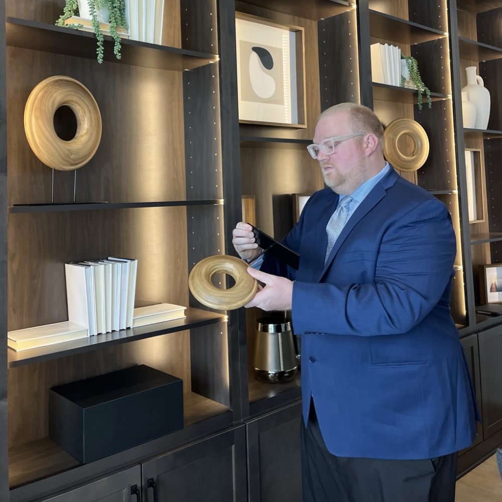 staff member in blue suit appraising a ring sculpture