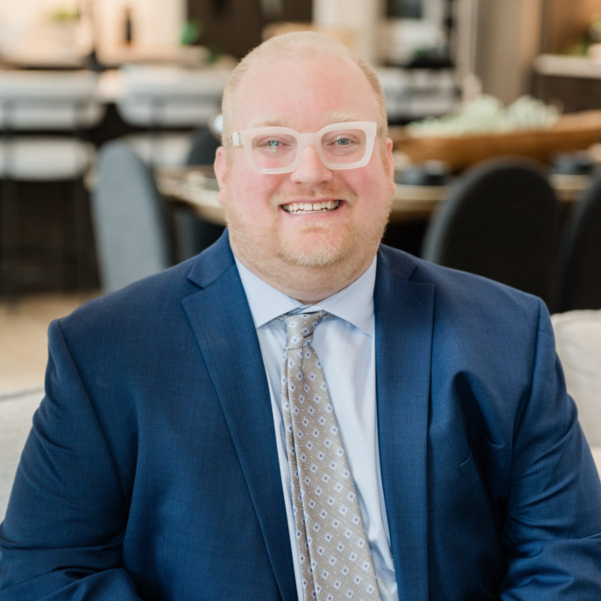 Derek Cooper, Project Manager and Certified Appraiser for Poof Estate Services; smiling man with light hair, facial hair, and light rimmed glasses