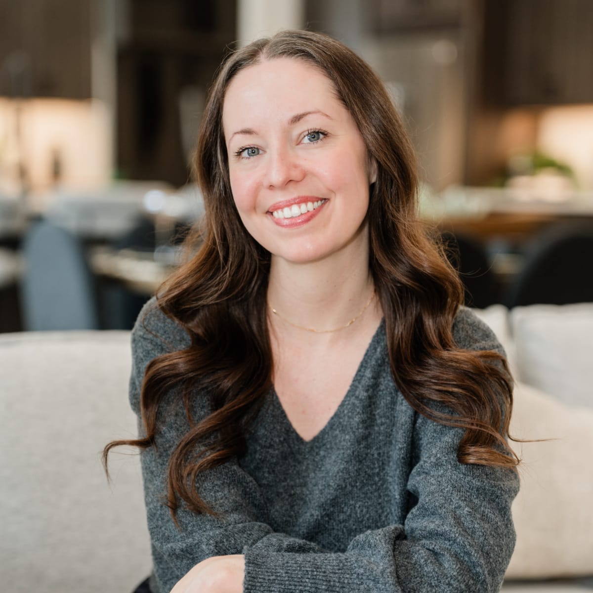 Peggy Ruby, co-owner and CEO of Poof Estate Services; smiling woman with long curled brown hair and bright eyes